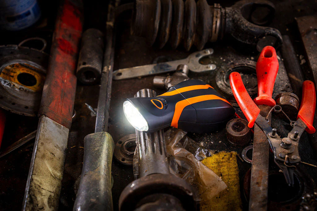 illumibite hands-free flashlight resting on a workbench with LEDs illuminated