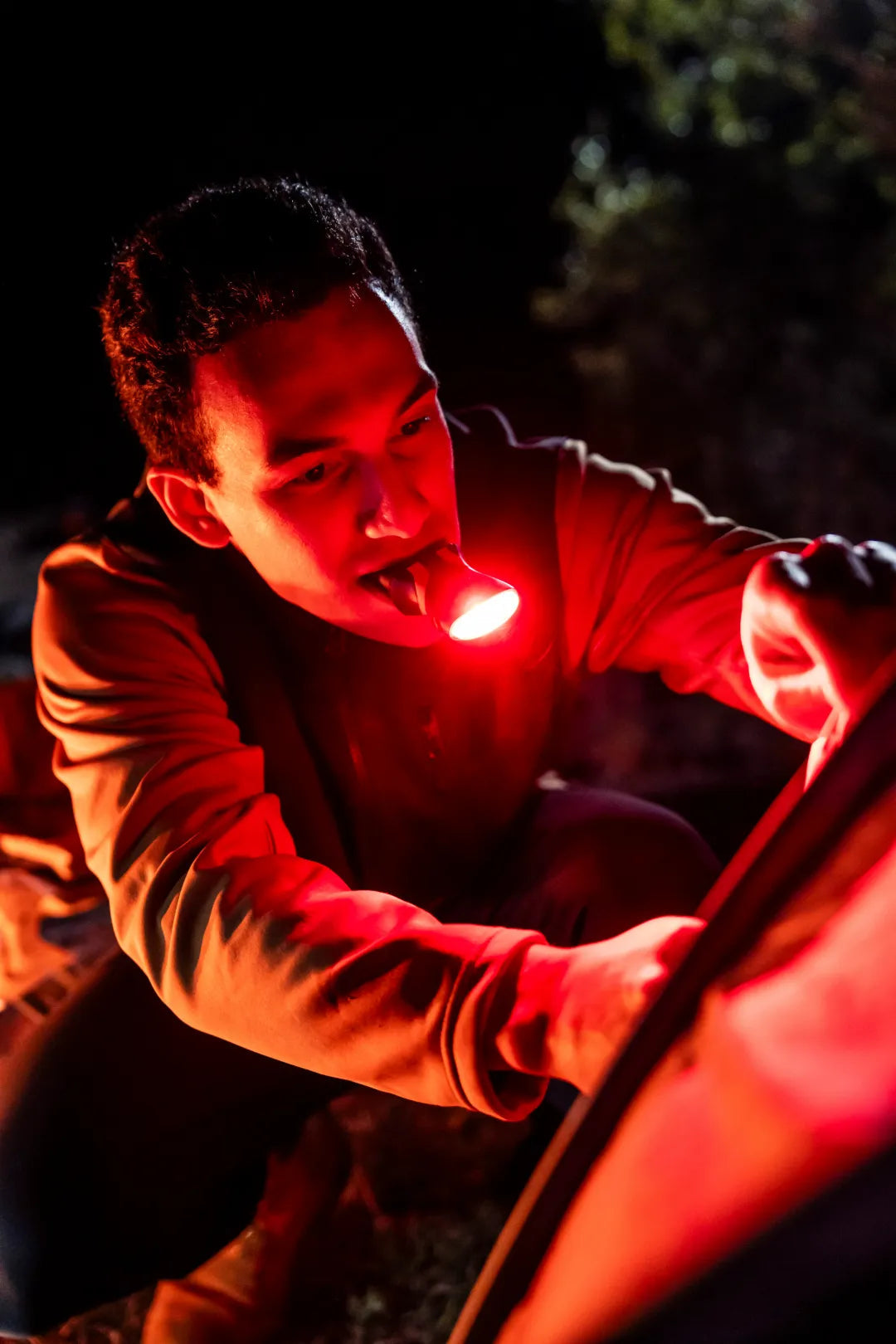illumibite red LED lighting used in a camping setup at night, delivering focused hands-free lighting for outdoor tasks and tent preparation